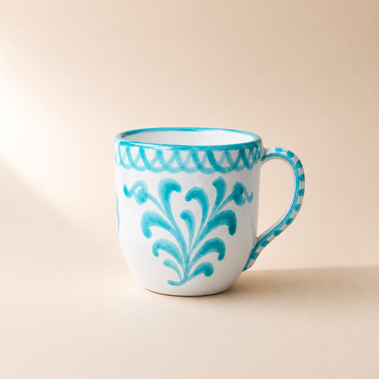 White mug with blue decorative patterns on a beige background