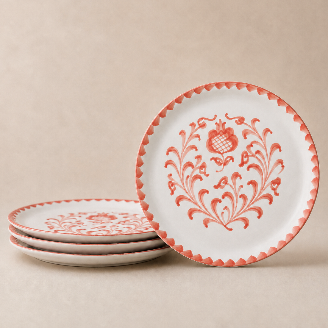 Set of ceramic plates with red floral patterns on a beige background
