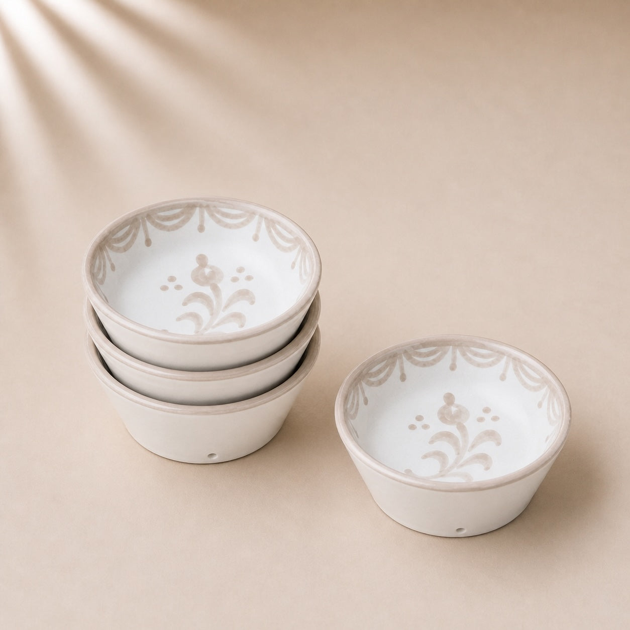 Set of white ceramic bowls with subtle patterns on a beige background