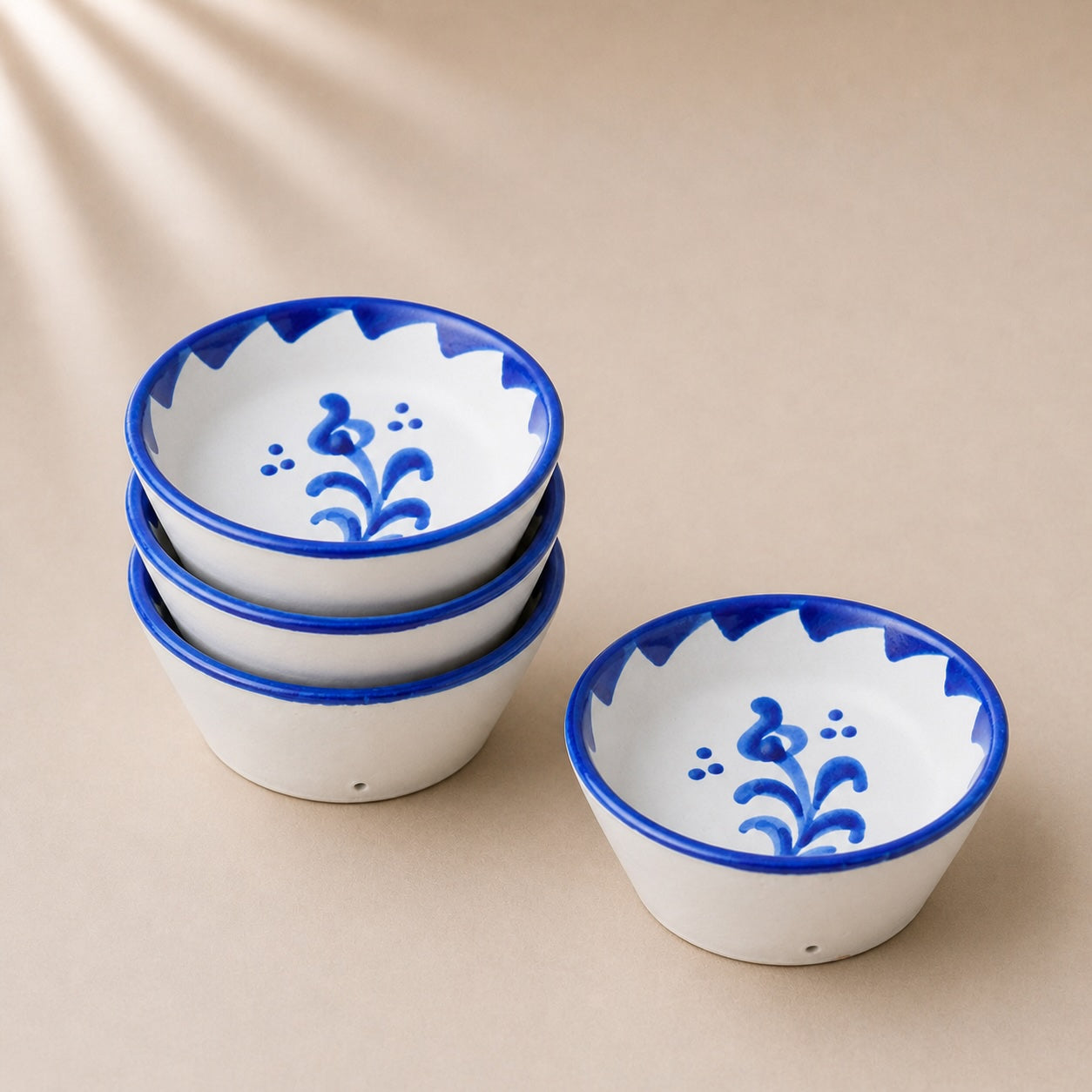 Set of ceramic bowls with blue floral designs on a beige background