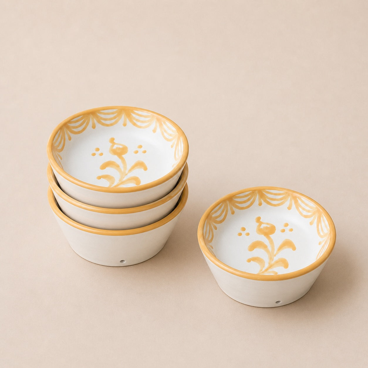 Set of ceramic bowls with gold decorative rims on a beige background