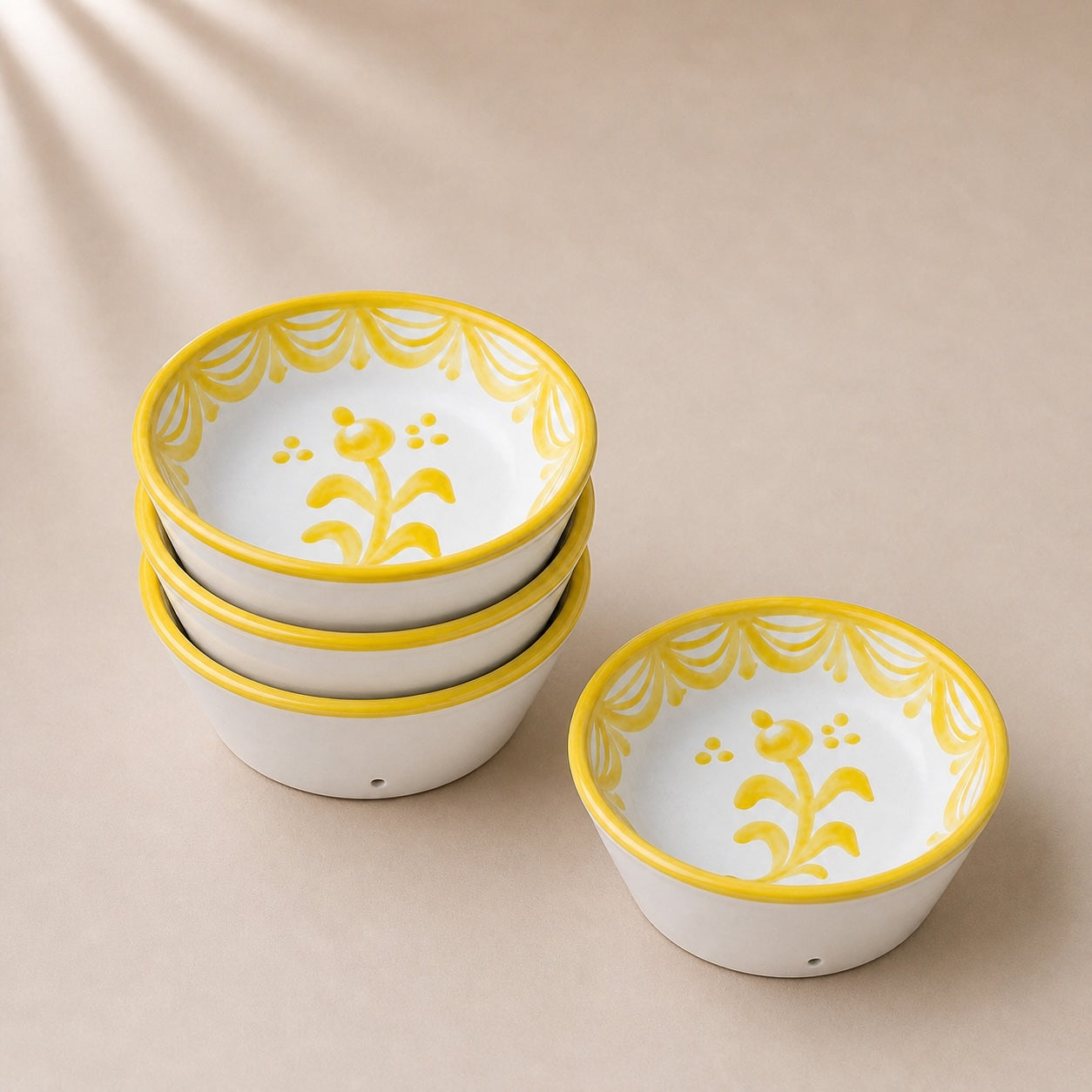 Set of ceramic bowls with yellow decorative rims on a beige background