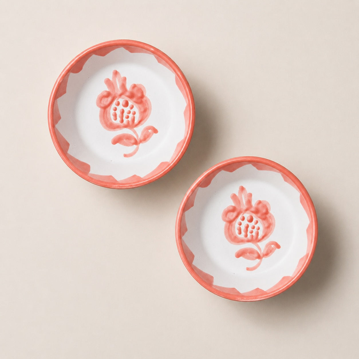 Two ceramic bowls with floral designs on a beige background