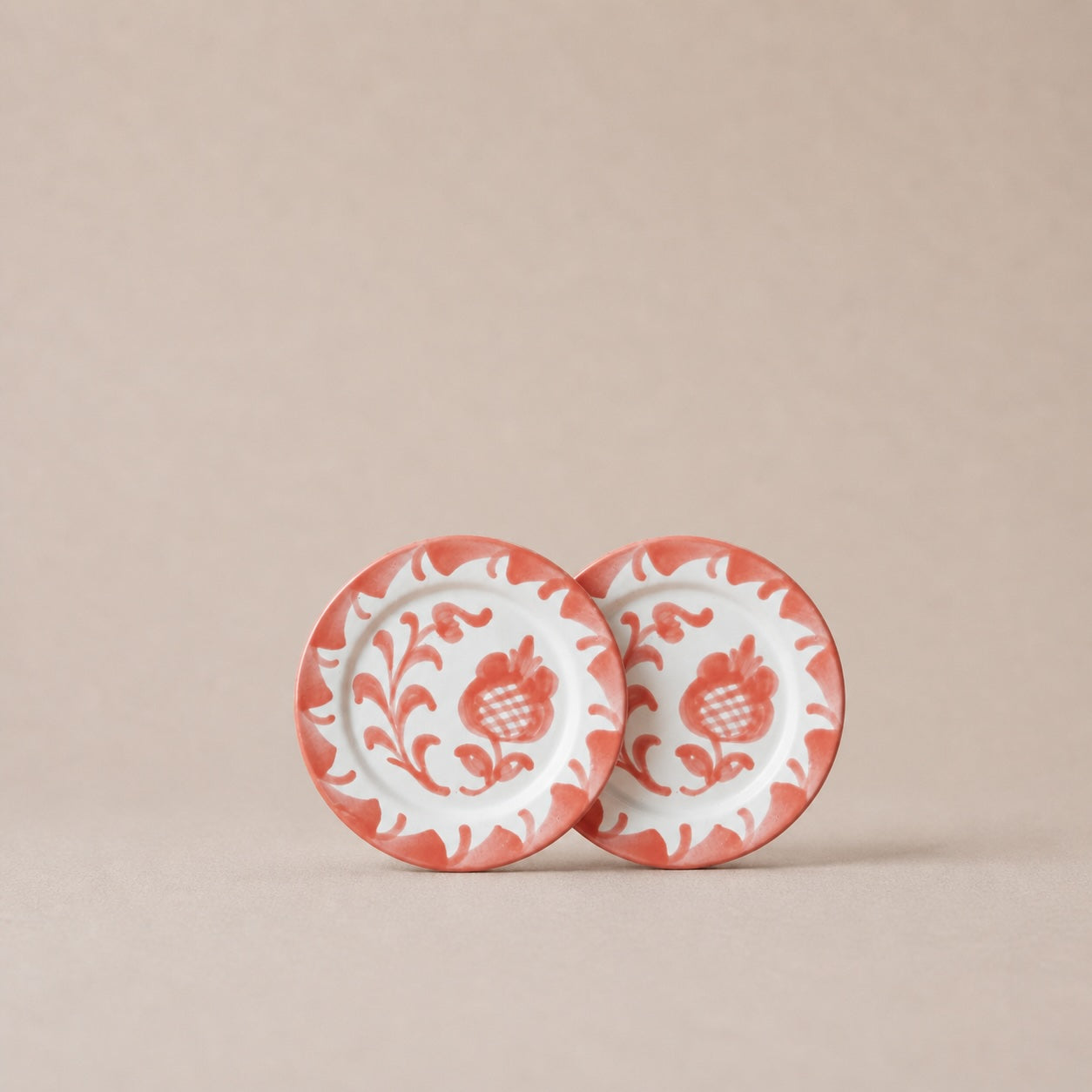 Two ceramic plates with floral patterns on a beige background