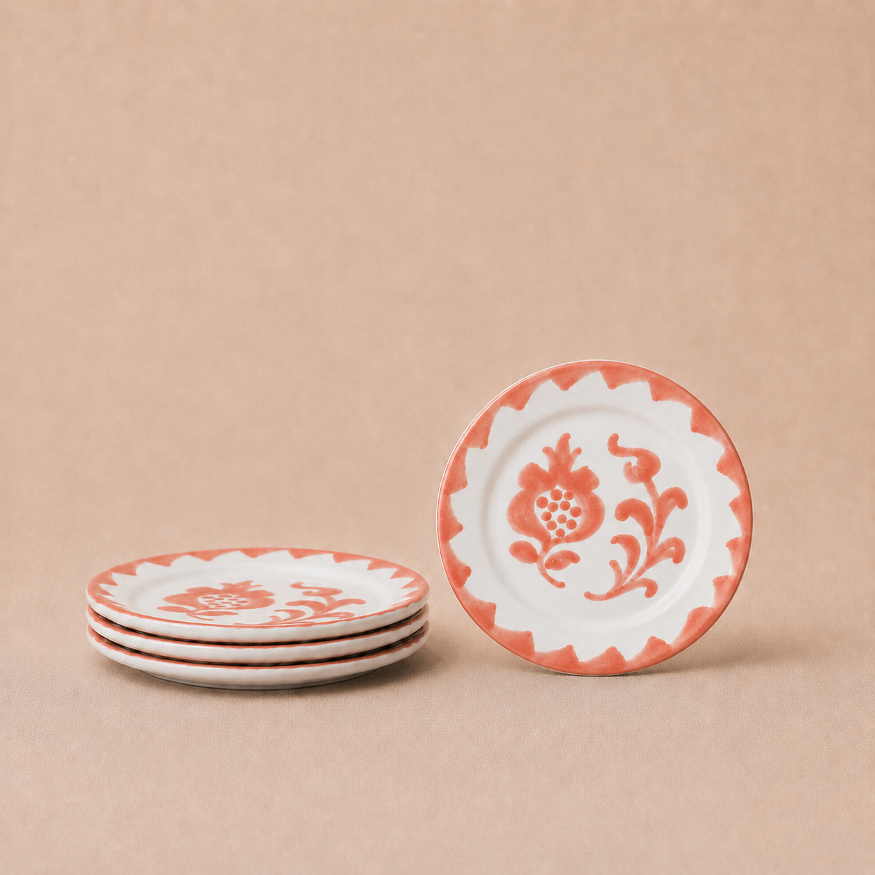 Set of four decorative plates with floral patterns on a beige background