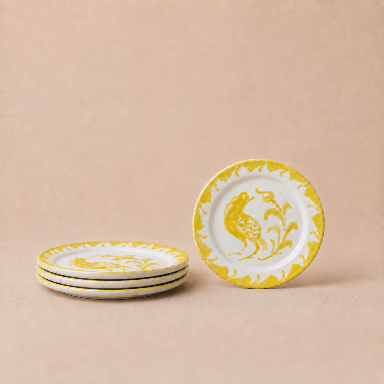Set of ceramic plates with yellow and white design on a beige background