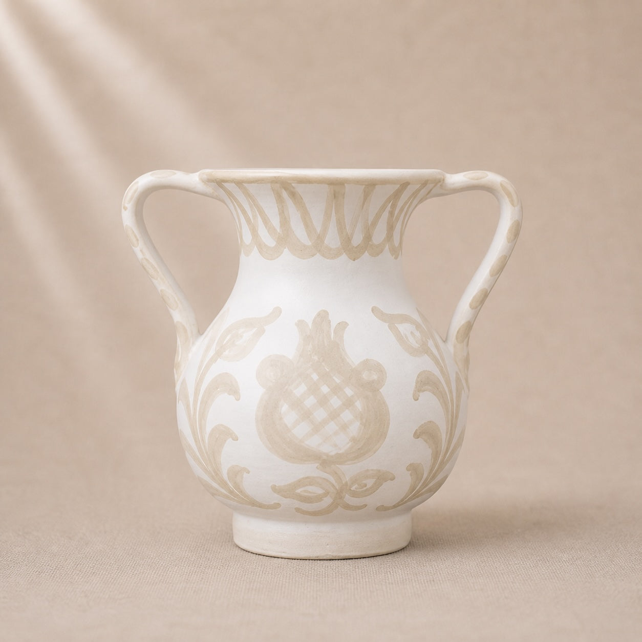 White ceramic vase with decorative patterns on a beige background