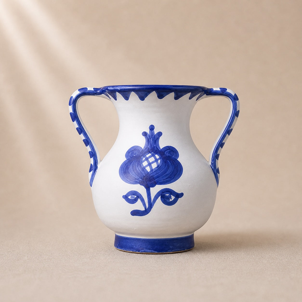 Ceramic vase with blue floral design on a beige background