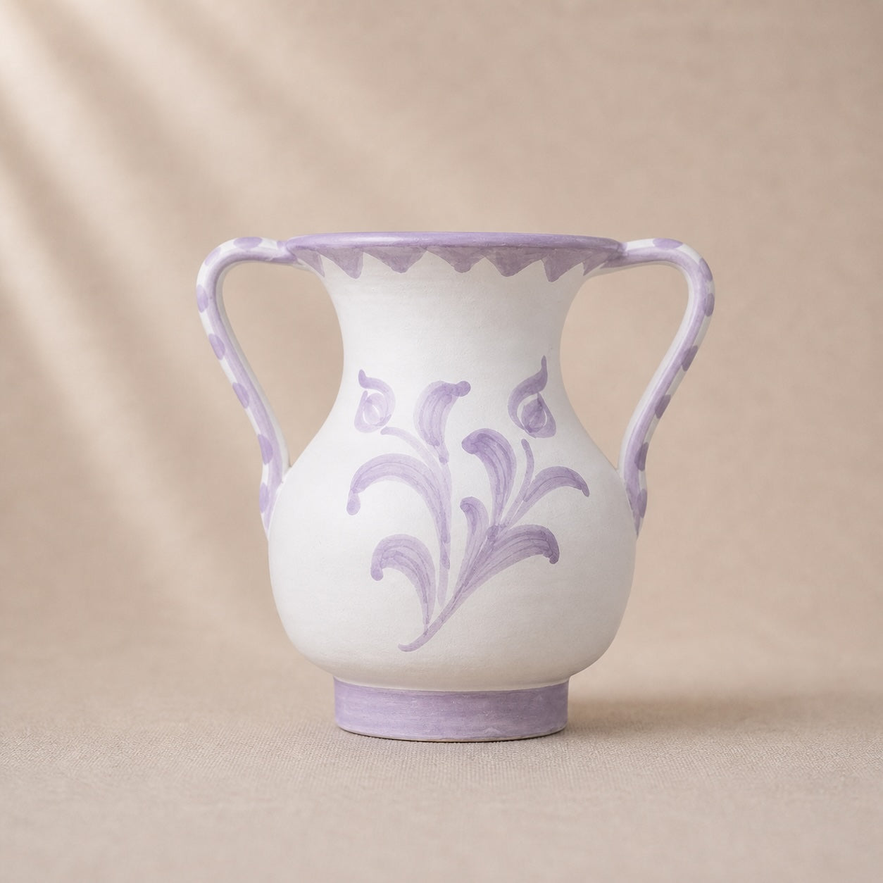 White vase with purple floral patterns and handles on a beige background
