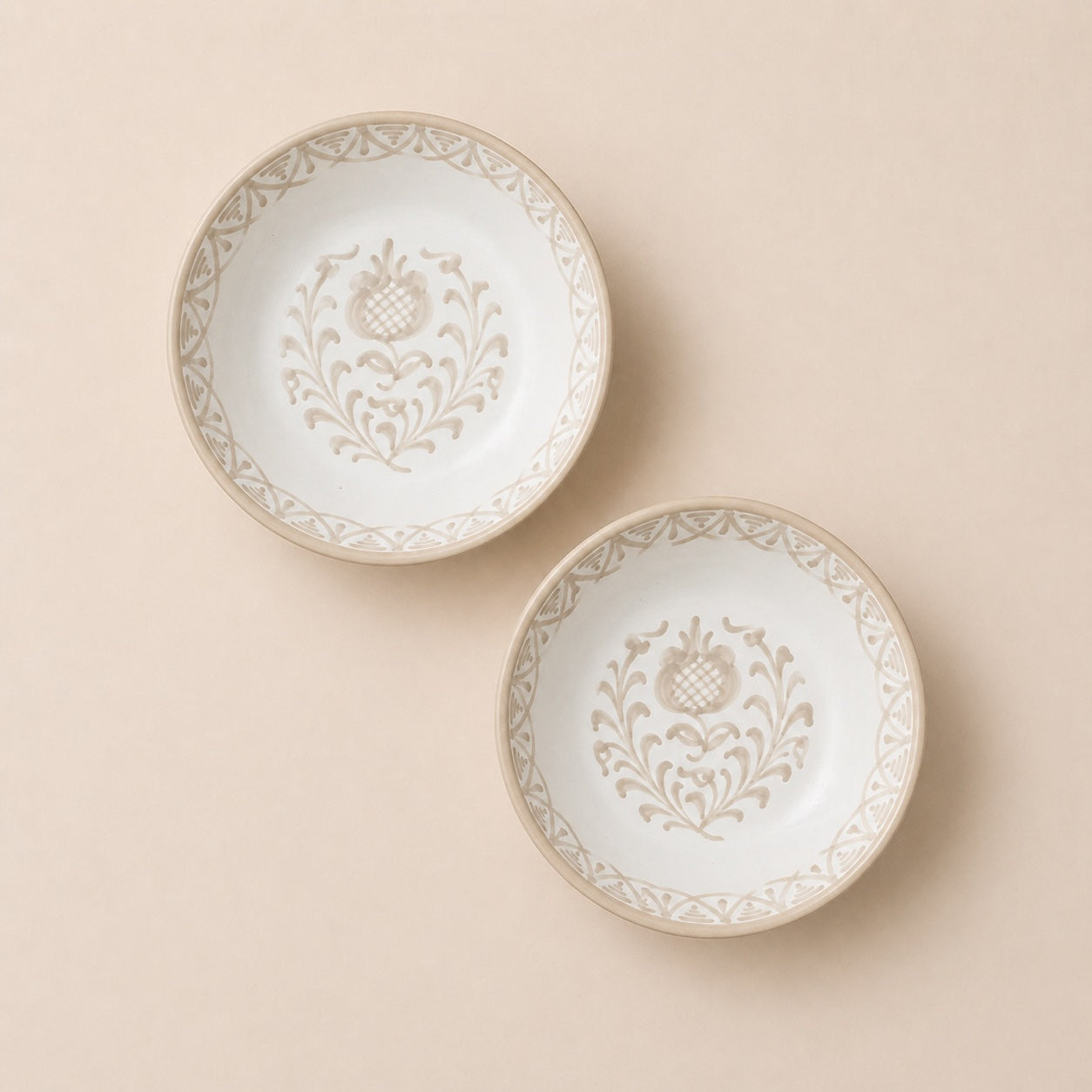 Two decorative plates with intricate patterns on a beige background