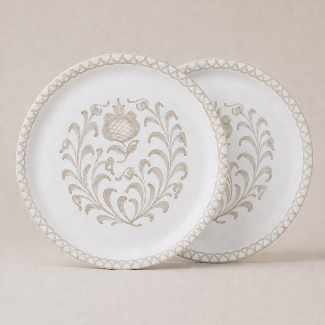 Two traditional dinner plates with intricate patterns on a beige background