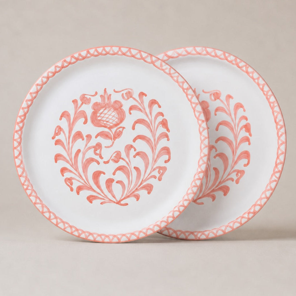 Two traditional dinner plates with pink floral patterns on a beige background