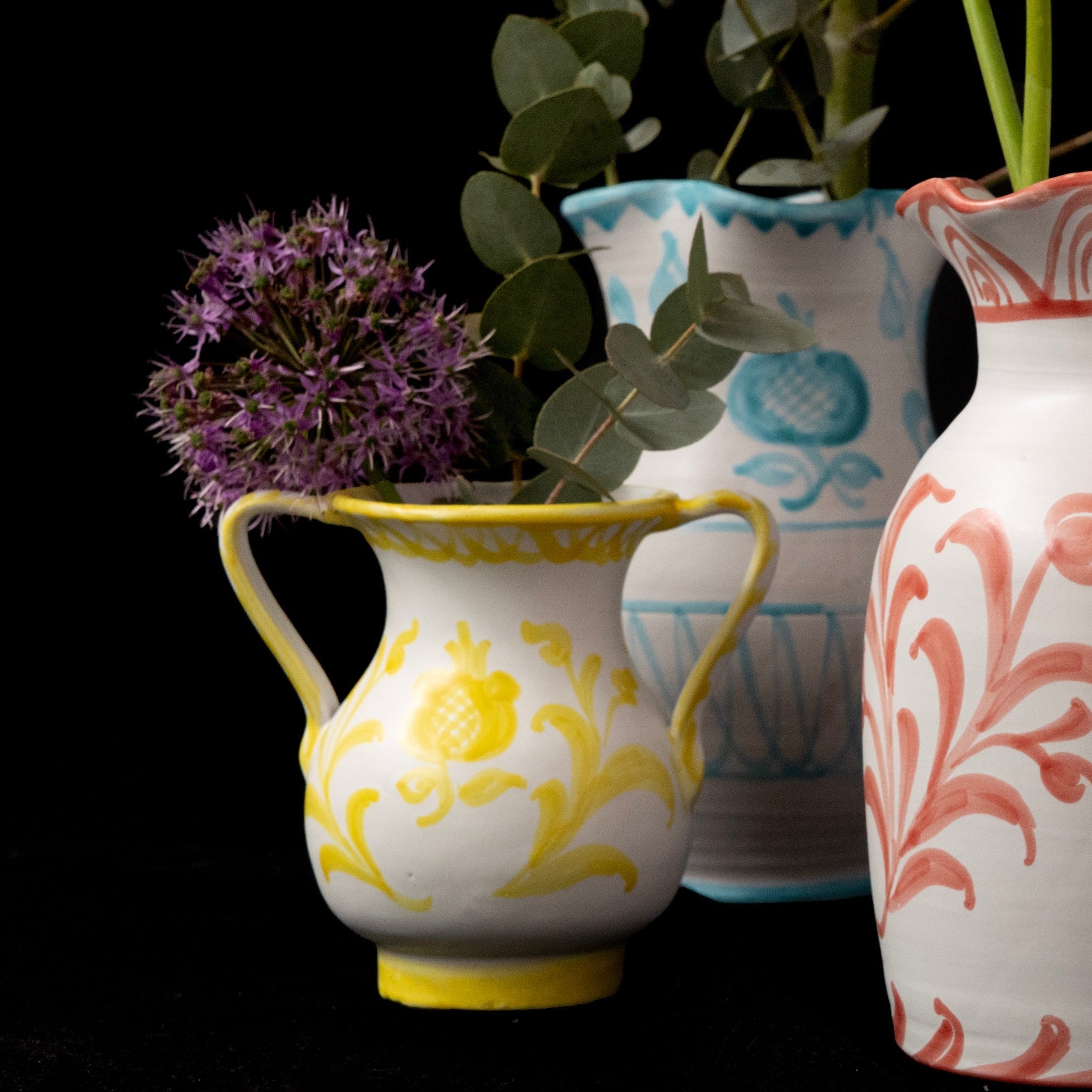 Four decorative vases with floral patterns on a black background - lifestyle