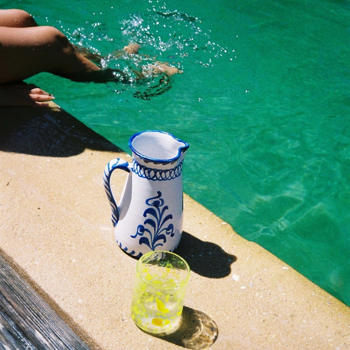 Person in a pool with a wide pitcher and glass from mallorca - lifestyle