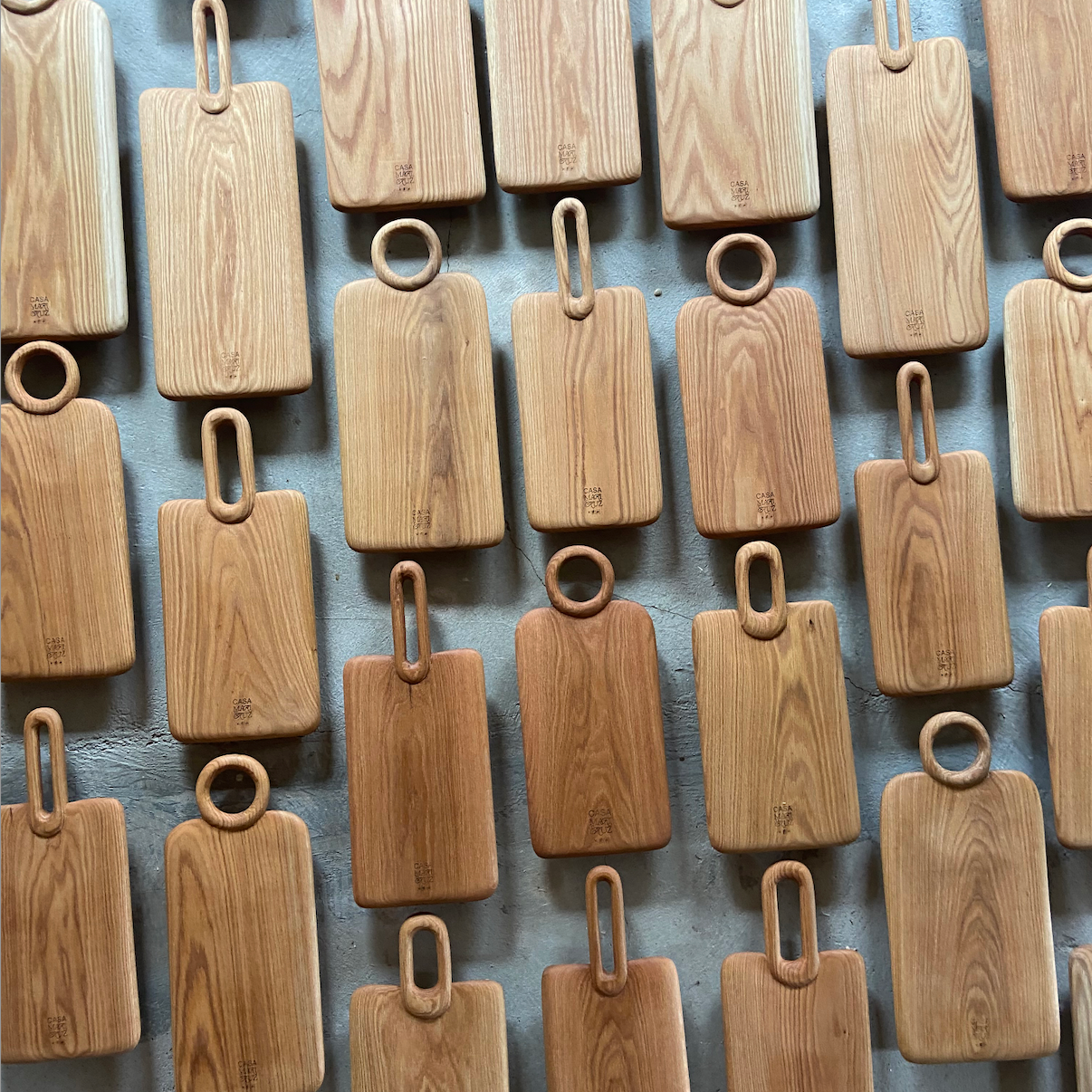 Pattern of wooden cutting boards with handles on a textured surface - lifestyle